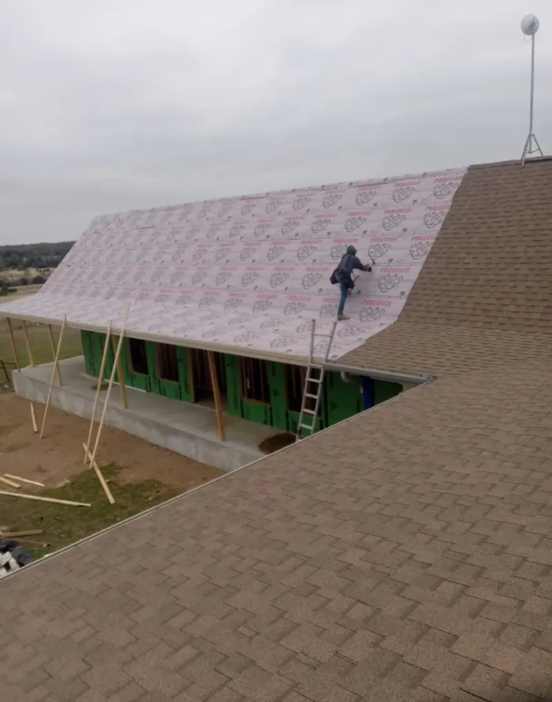 Worker preparing underlayment for a metal roof installation in Upper Sandusky